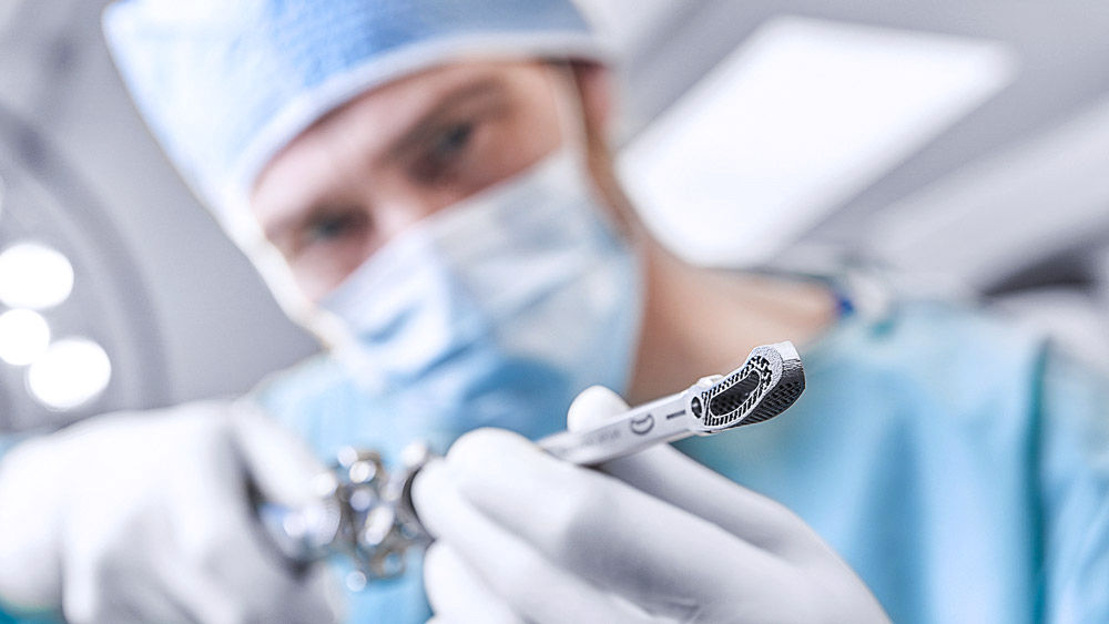 Chirurg drží nástroj s 3D implantátom na medzistavcovú fúziu