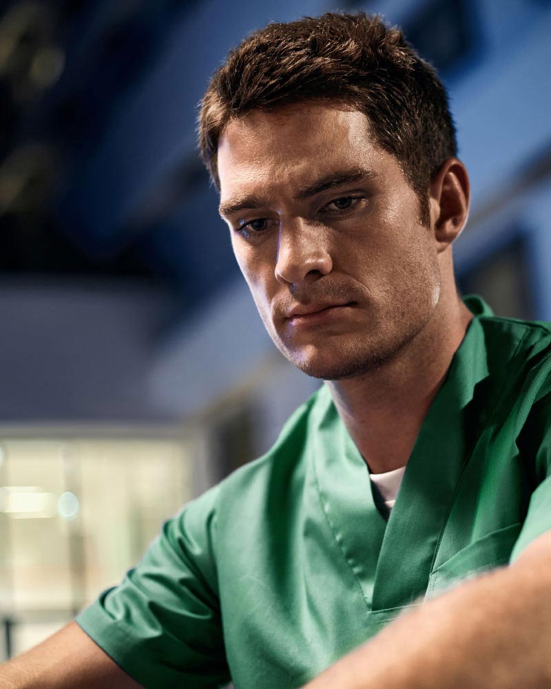 Vyčerpaná sestra sediaca pred nemocnicou