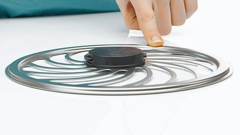 Ruka sa dotýka kovového predmetu v tvare kolesa, ktorý môže byť súčasťou zdravotníckeho zariadenia alebo vybavenia