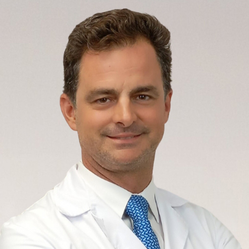 Portrét profesora Javiera Lópeza Monclúsa v doktorskom kabáte, ktorý sa sebavedomo usmieva do kamery