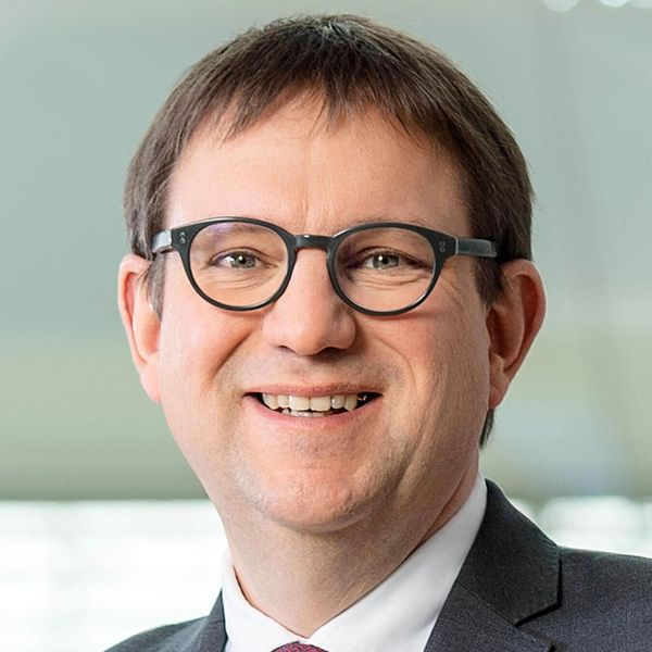 Detailný záber na usmievajúceho sa docenta. Dr. Stefan Ruppert, člen predstavenstva, riaditeľ pre ľudské zdroje a riaditeľ pre pracovné vzťahy. 